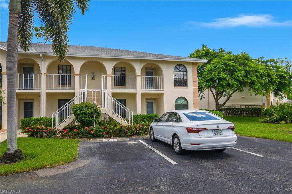 701 Augusta Boulevard, Unit 7018 Naples, FL 34113 - Photo 26 of 30 a car parked in front of white house with a yard