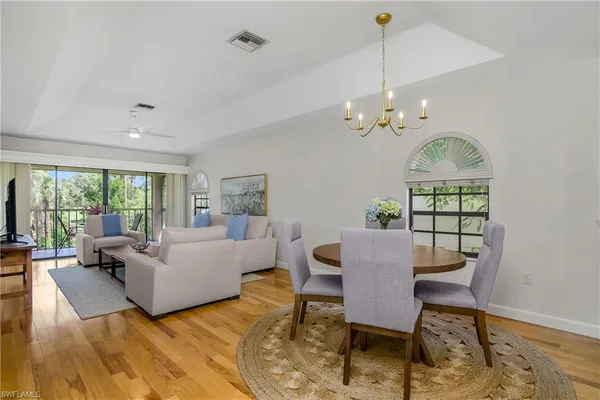 a living room with furniture dining table and a chandelier