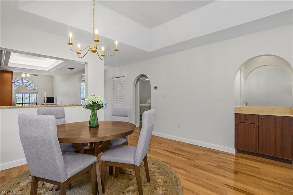701 Augusta Boulevard, Unit 7018 Naples, FL 34113 - Photo 7 of 30 a view of a dining room with furniture and wooden floor