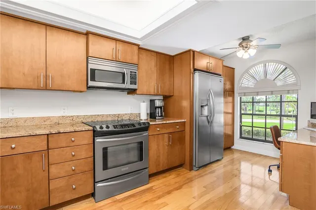 a kitchen with stainless steel appliances granite countertop a refrigerator a stove a sink and a microwave