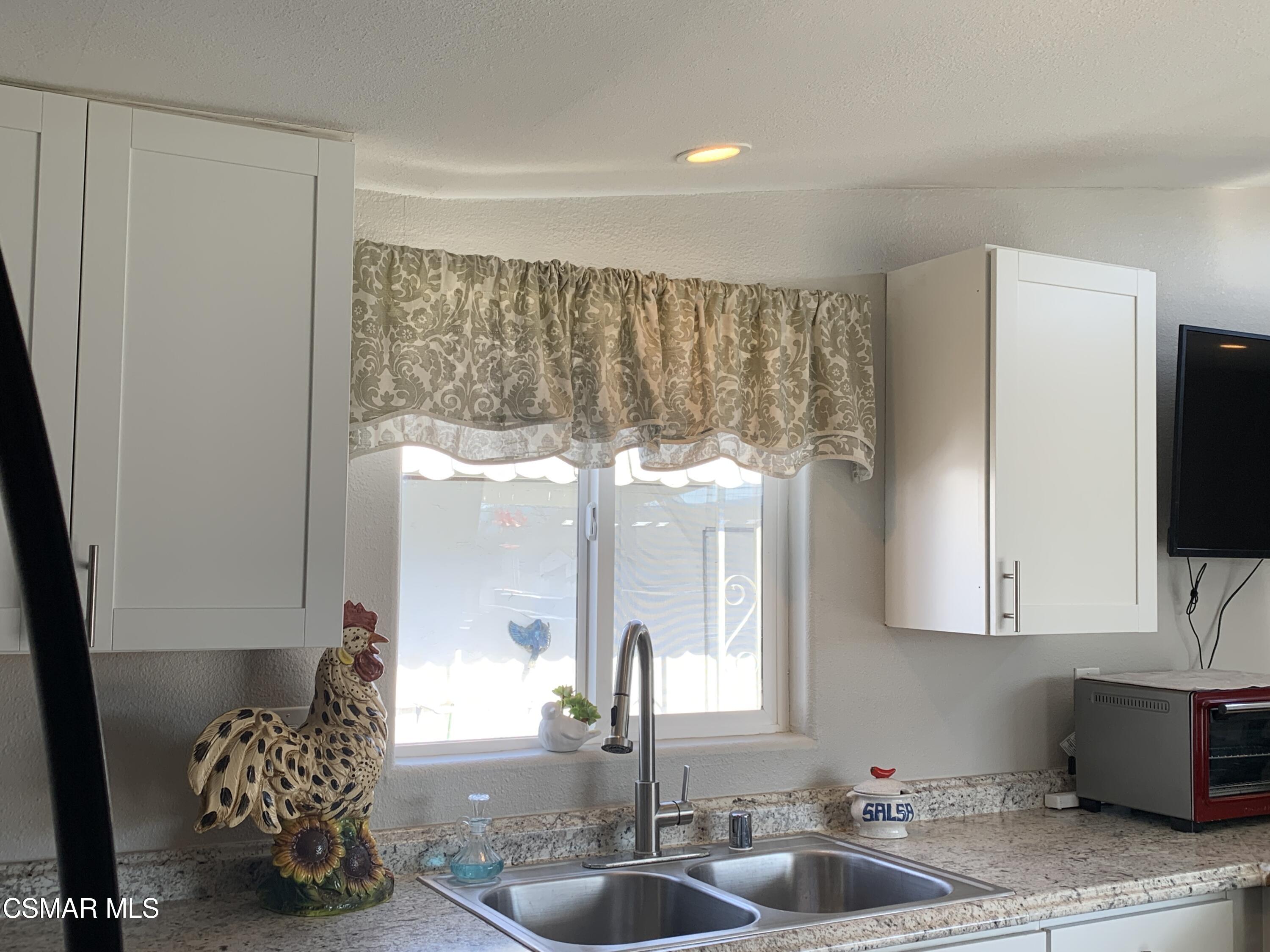 4381 Cochran Street, Unit 10 Simi Valley, CA 93063 - Photo 11 of 32 a kitchen with a sink window and cabinets