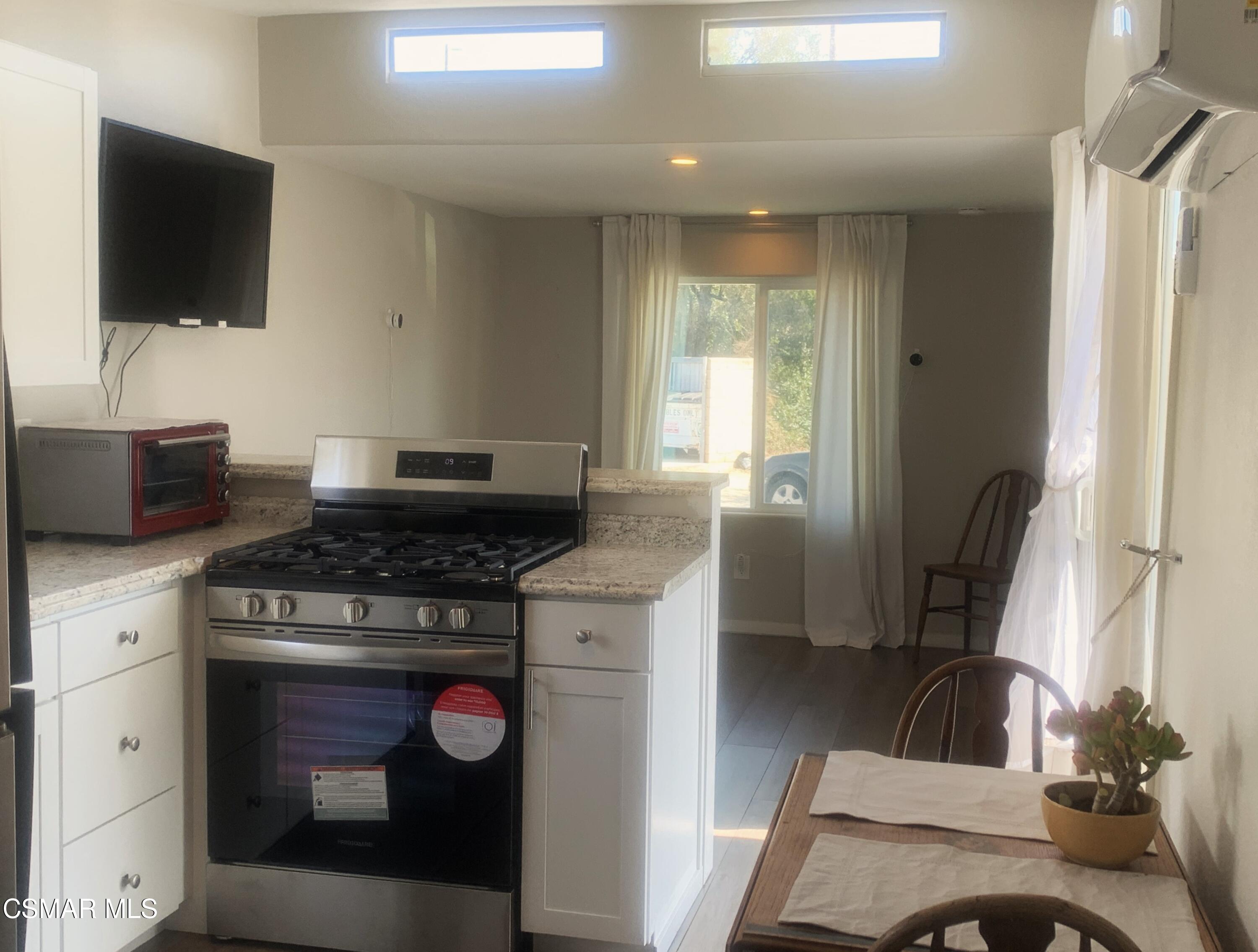 4381 Cochran Street, Unit 10 Simi Valley, CA 93063 - Photo 5 of 32 a kitchen with a stove and a flat screen tv