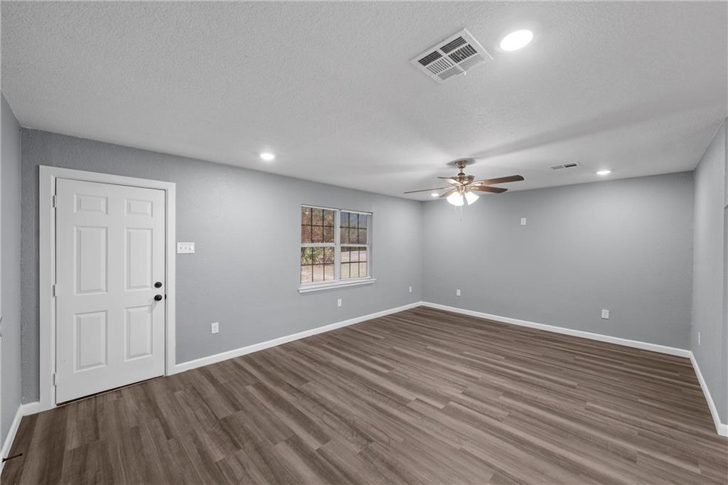 12932 Old Dallas Road West, TX 76691 - Photo 3 of 16 wooden floor in an empty room with a window