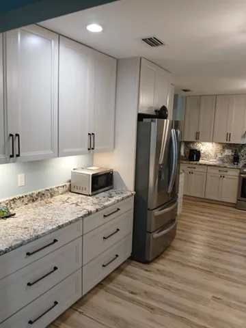 a bed sitting in a bedroom next to a window with furniture