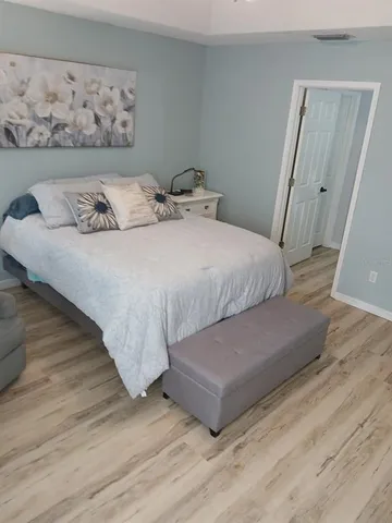 a bedroom with a bed and wooden floor
