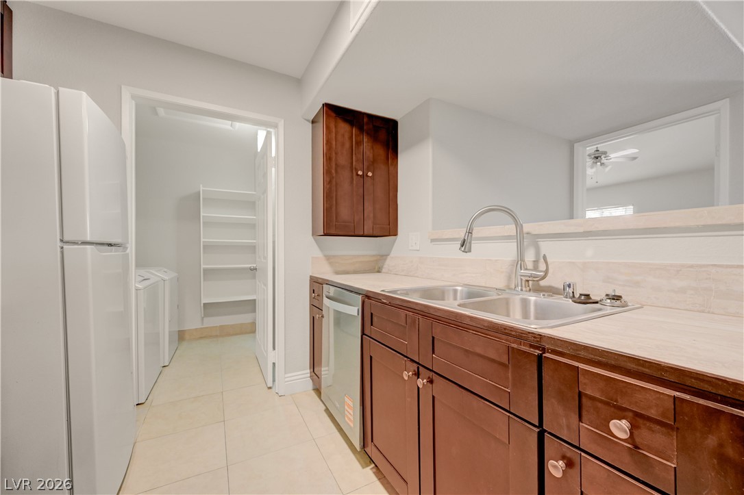 7885 West Flamingo Road, Unit 1050 Las Vegas, NV 89147 - Photo 16 of 62 Functional kitchen with ample cabinet space, a dual sink, and adjacent laundry access.