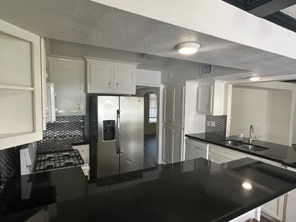a kitchen with stainless steel appliances granite countertop a refrigerator and a sink