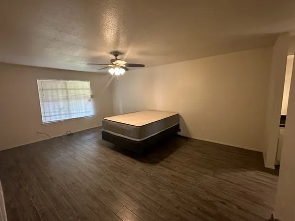 a spacious bedroom with a bed and a chandelier