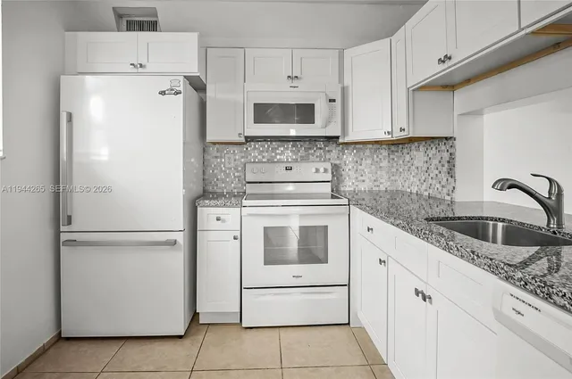 a white refrigerator freezer sitting inside of a kitchen