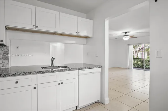 a kitchen with granite countertop a sink and cabinets