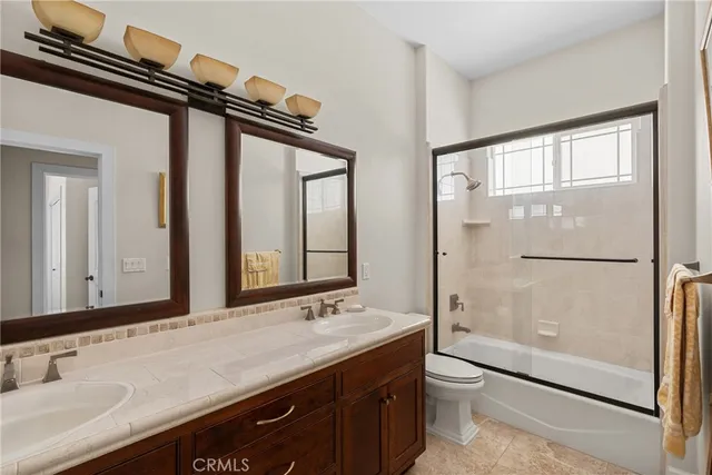 a bathroom with a granite countertop sink mirror toilet and bathtub