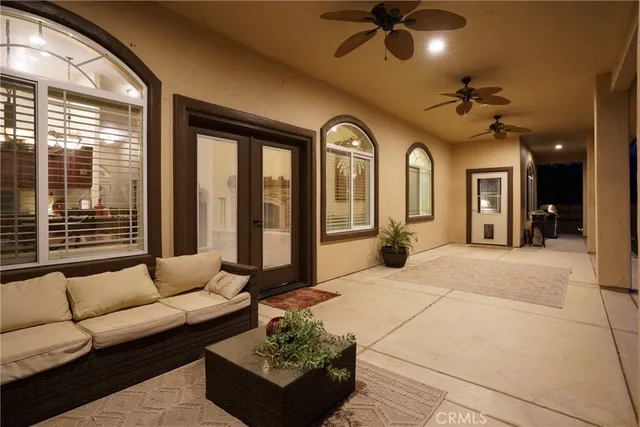 a living room with furniture ceiling fan and a large window