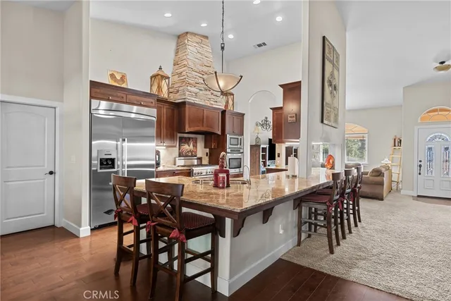 a view of a dining room and livingroom with furniture wooden floor a chandelier