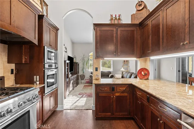 a kitchen with stainless steel appliances granite countertop a stove a sink and a refrigerator