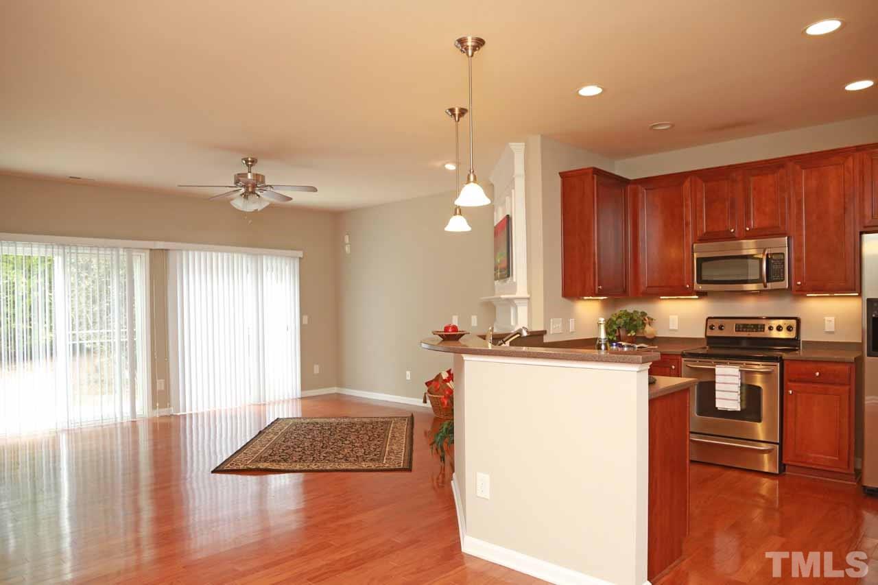 7114 Racine Way Raleigh, NC 27615 - Photo 4 of 23 a kitchen with kitchen island granite countertop a stove top oven a sink a counter space and cabinets