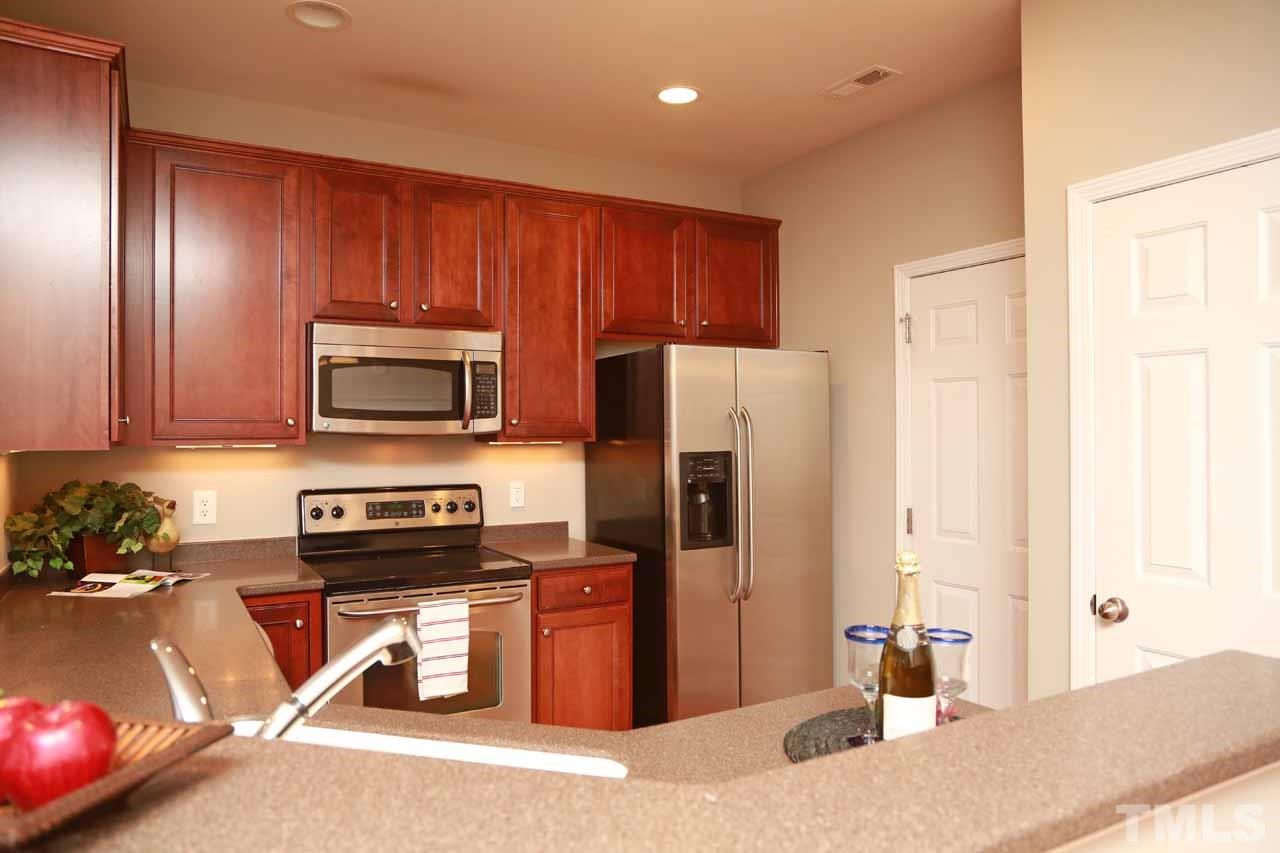 7114 Racine Way Raleigh, NC 27615 - Photo 5 of 23 a kitchen with stainless steel appliances granite countertop a refrigerator and a sink