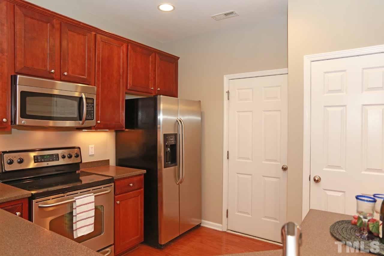 7114 Racine Way Raleigh, NC 27615 - Photo 6 of 23 a kitchen with stainless steel appliances granite countertop a refrigerator stove and microwave