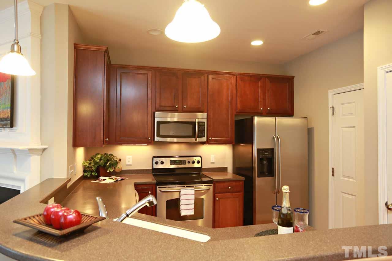 7114 Racine Way Raleigh, NC 27615 - Photo 7 of 23 a kitchen with stainless steel appliances granite countertop a refrigerator stove and sink