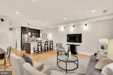 a living room with furniture kitchen view and a flat screen tv