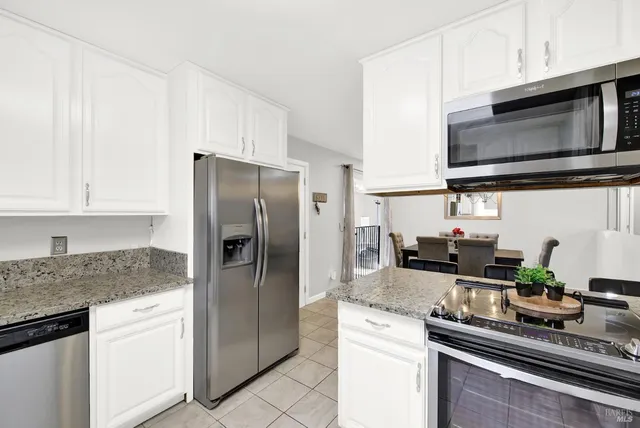 a kitchen with stainless steel appliances granite countertop a refrigerator stove and microwave