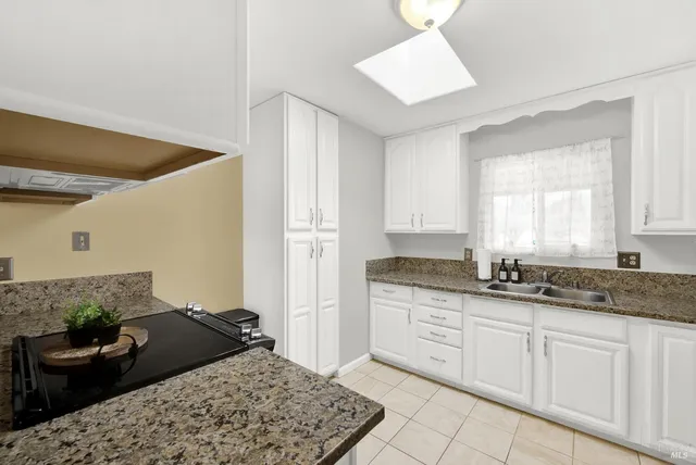 a kitchen with granite countertop a sink and cabinets