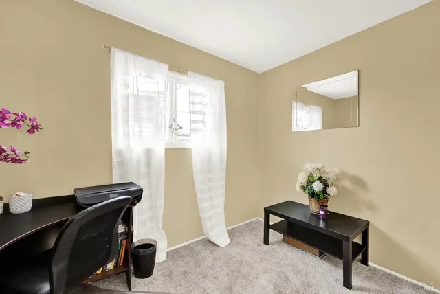 a view of a workspace with furniture and a window