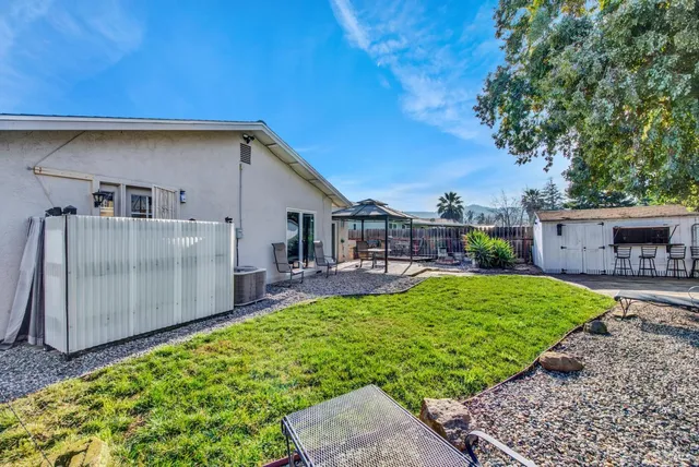 a view of a house with backyard sitting area and garden