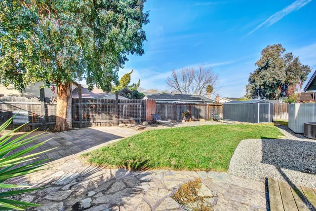a view of backyard with swimming pool and seating space