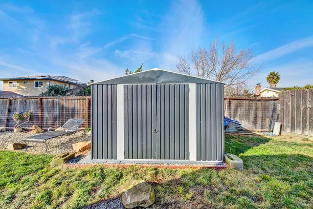 a view of a house with a small yard and wooden fence