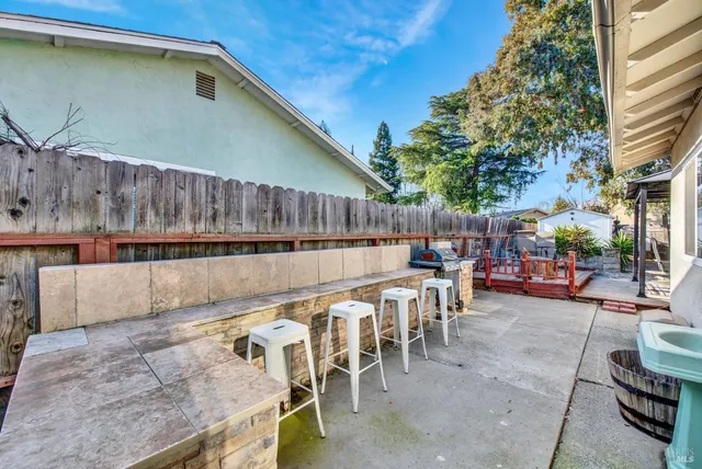 a view of a patio with table and chairs with wooden floor and fence