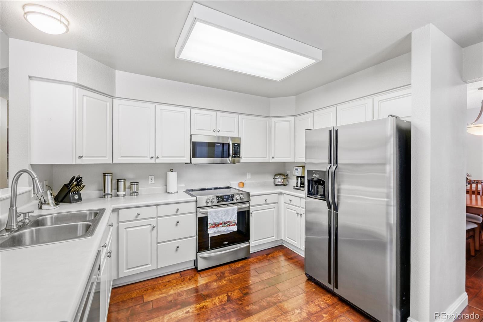 456 Bexley Lane Highlands Ranch, CO 80126 - Photo 10 of 28 a kitchen with stainless steel appliances granite countertop a refrigerator sink and stove
