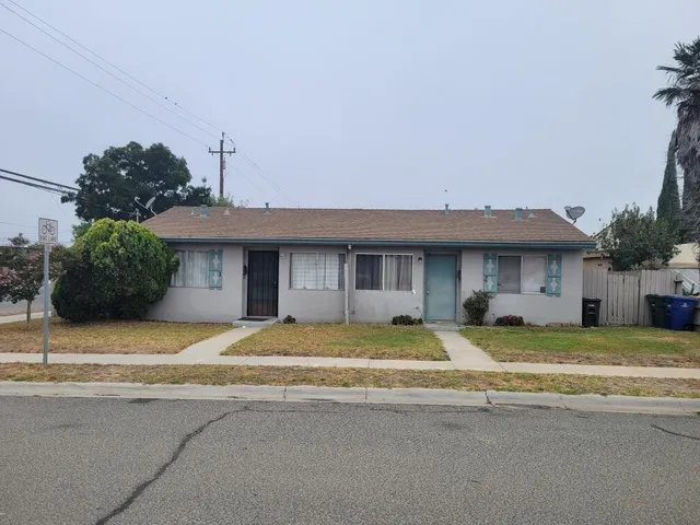 a view of a house with basketball space and a car parked on the road