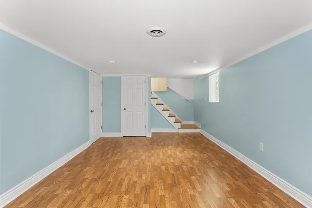 a view of a big room with wooden floor and stairs