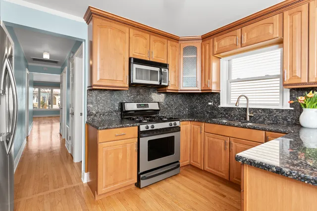 a kitchen with stainless steel appliances granite countertop a stove a sink and a microwave