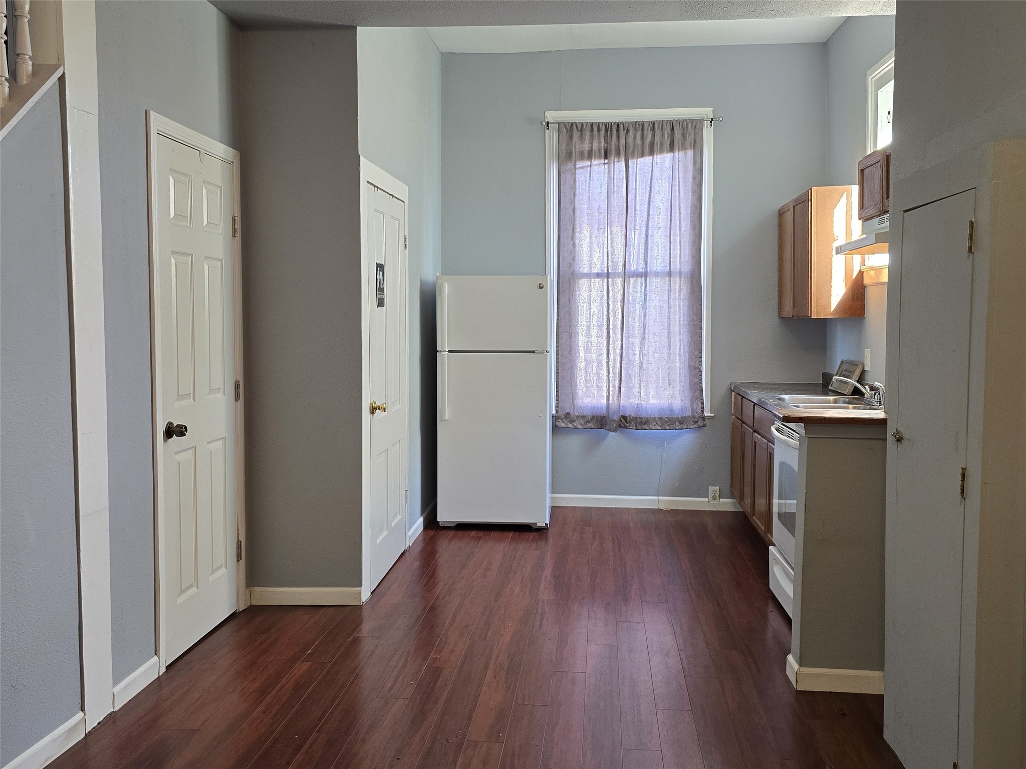 1614 Market Street, Unit 4 Galveston, TX 77550 - Photo 7 of 19 a view of a kitchen with a fridge wooden floor and a window