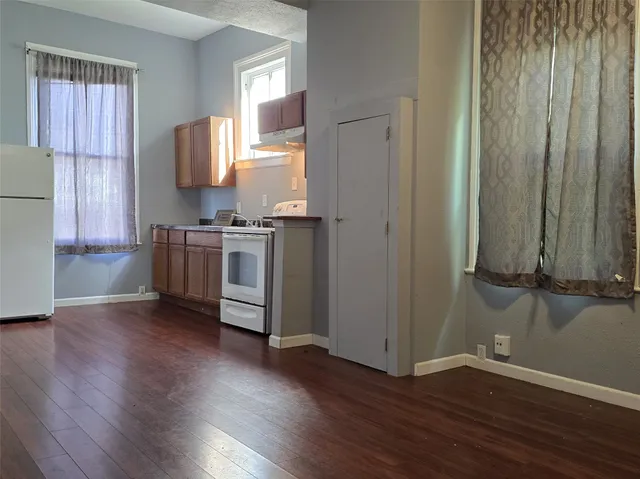 a view of a kitchen with a sink cabinets and wooden floor