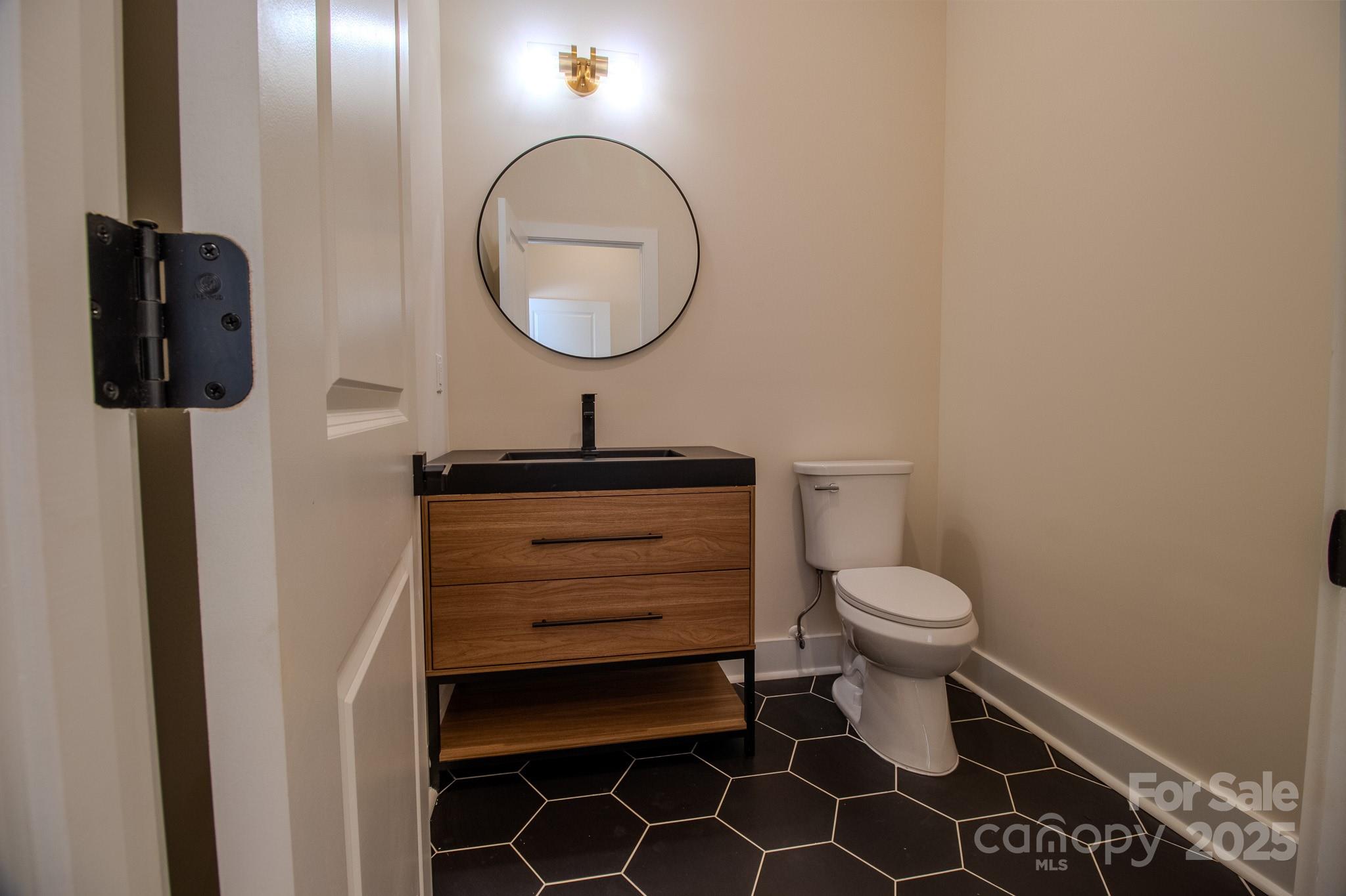 1429 Coppergate Drive Salisbury, NC 28147 - Photo 14 of 37 a bathroom with a toilet a sink and mirror