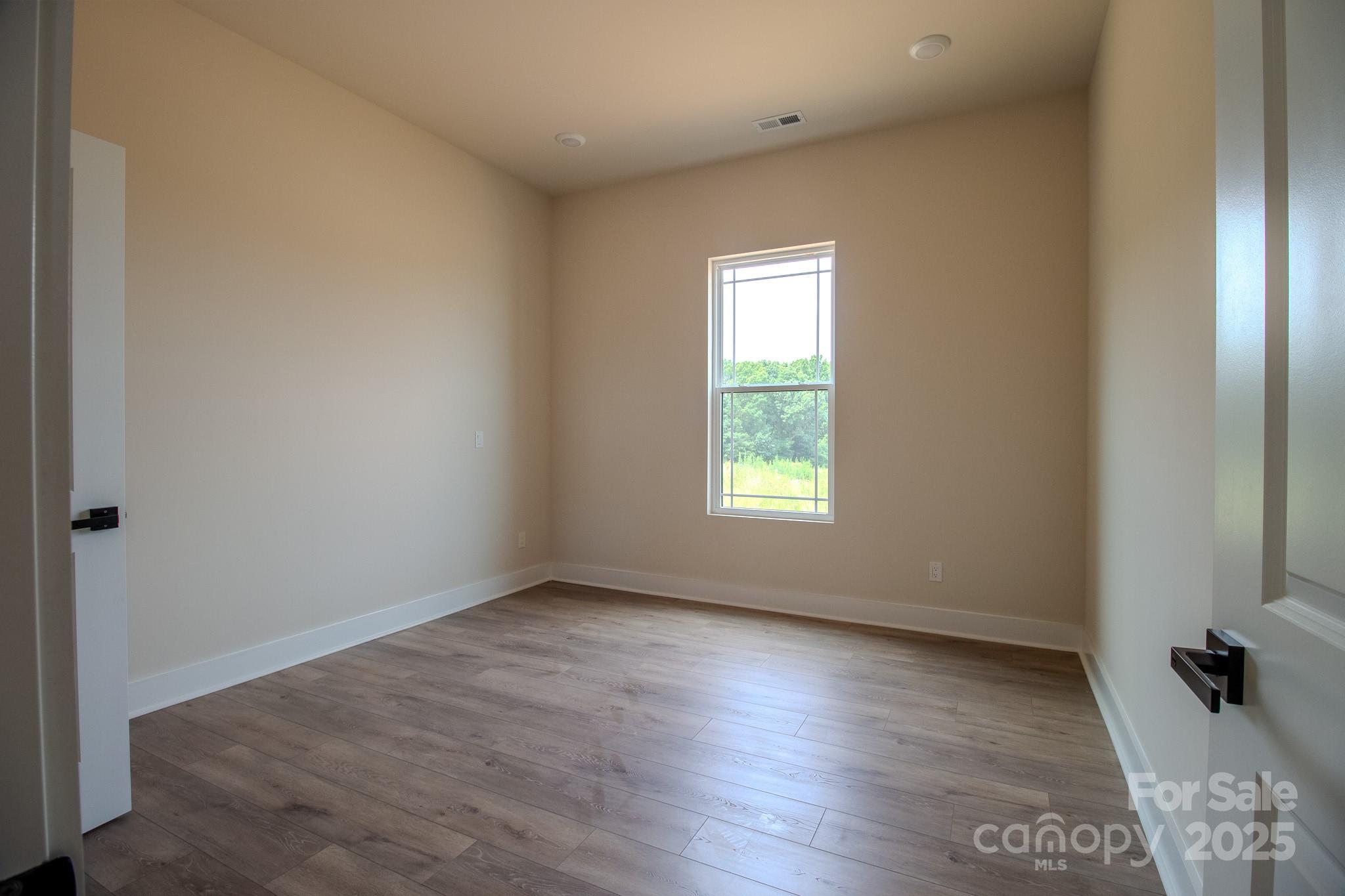 1429 Coppergate Drive Salisbury, NC 28147 - Photo 22 of 37 an empty room with wooden floor and windows