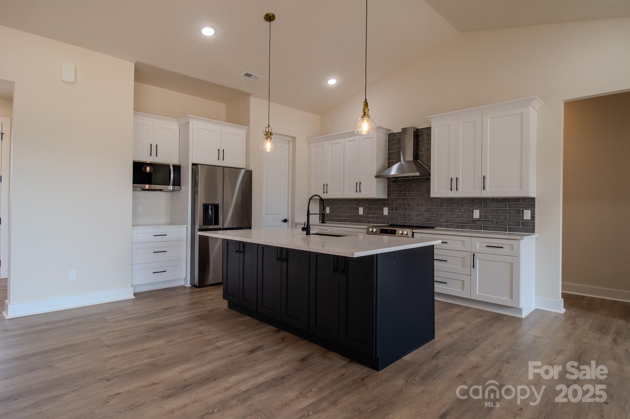 1429 Coppergate Drive Salisbury, NC 28147 - Photo 8 of 37 a kitchen with stainless steel appliances granite countertop a refrigerator stove a sink and white cabinets with wooden floor