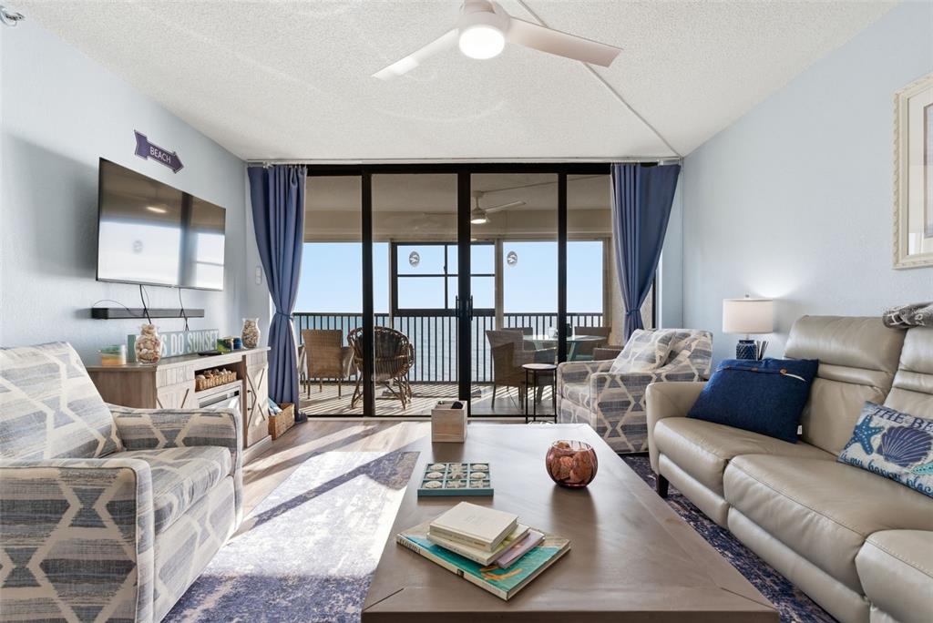 15462 Gulf Boulevard, Unit 406 Madeira Beach, FL 33708 - Photo 11 of 48 a living room with furniture and a floor to ceiling window