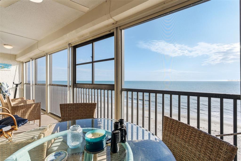 15462 Gulf Boulevard, Unit 406 Madeira Beach, FL 33708 - Photo 13 of 48 a view of a chair and tables in the balcony