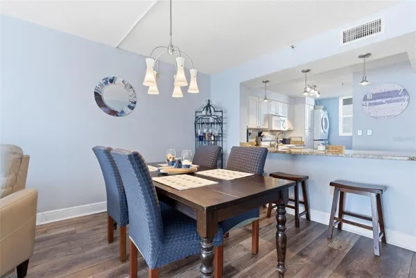 a kitchen with a dining table chairs sink and refrigerator