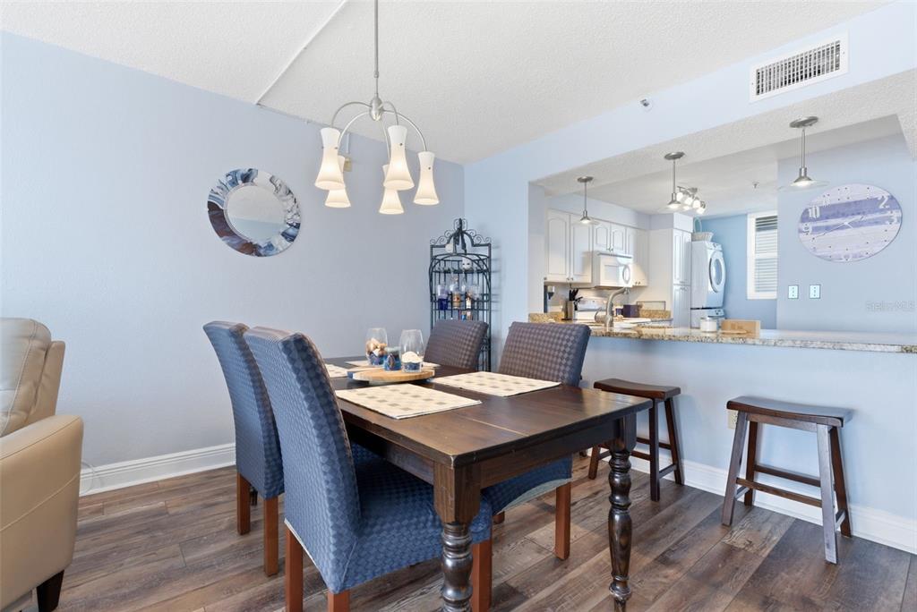 15462 Gulf Boulevard, Unit 406 Madeira Beach, FL 33708 - Photo 17 of 48 a view of a dining room with furniture wooden floor and chandelier
