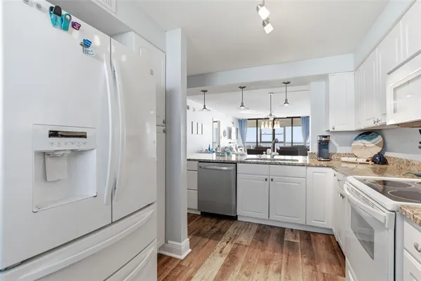 a kitchen with granite countertop a sink a counter top space and living room view