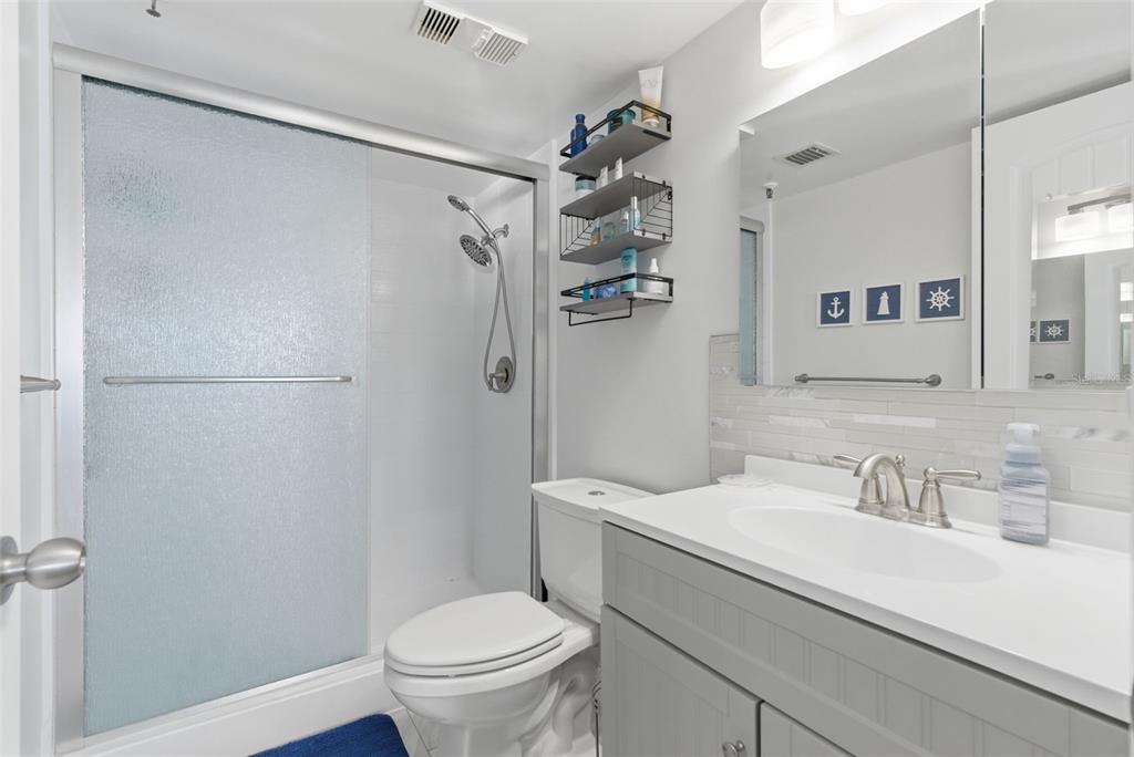 15462 Gulf Boulevard, Unit 406 Madeira Beach, FL 33708 - Photo 27 of 48 a bathroom with a sink a toilet and shower