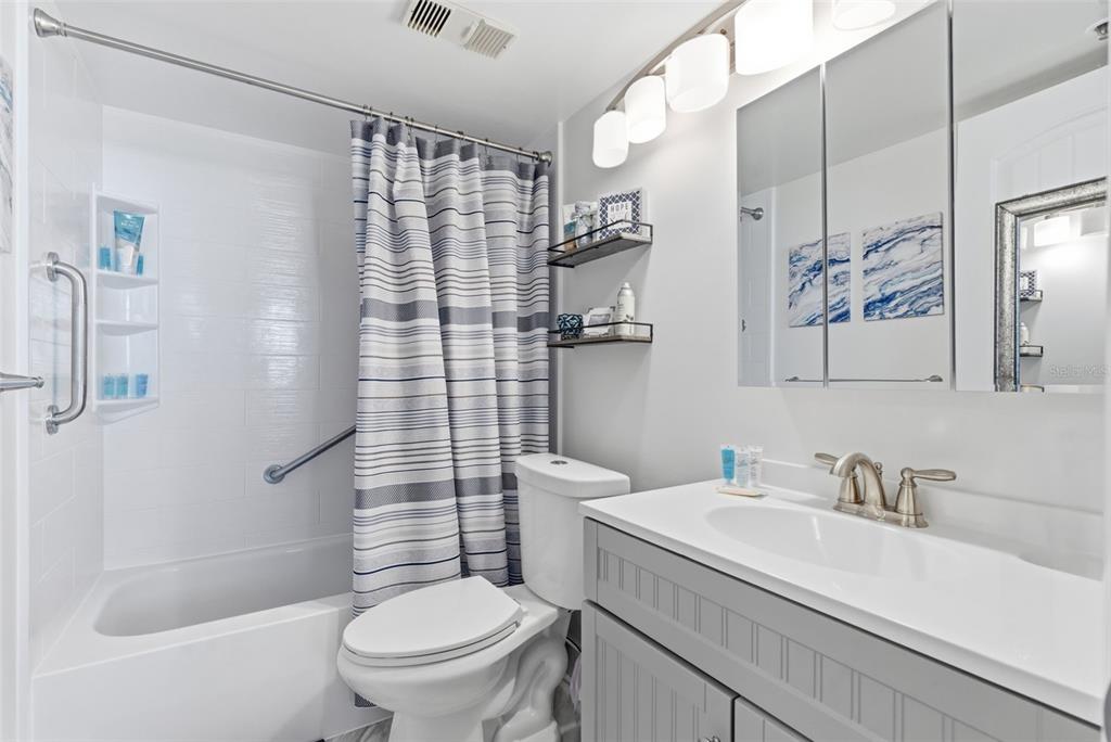 15462 Gulf Boulevard, Unit 406 Madeira Beach, FL 33708 - Photo 30 of 48 a bathroom with a granite countertop sink a toilet and shower