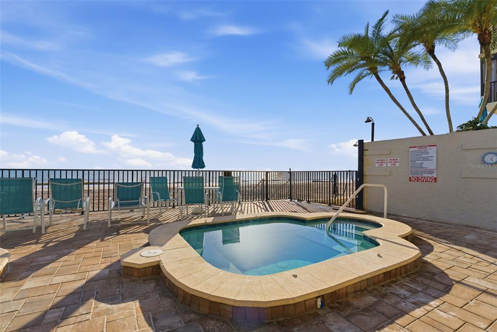 15462 Gulf Boulevard, Unit 406 Madeira Beach, FL 33708 - Photo 34 of 48 a view of a swimming pool with a lounge chair
