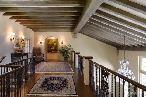 a spacious bedroom with a bed a chandelier and couch