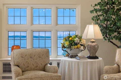 a bathroom with a double vanity sink a large mirror a bathtub and next to a window