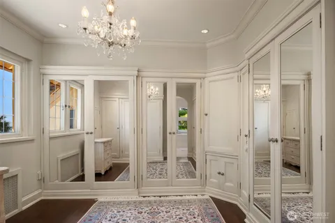 a bathroom with a granite countertop double vanity sink a mirror and a bathtub